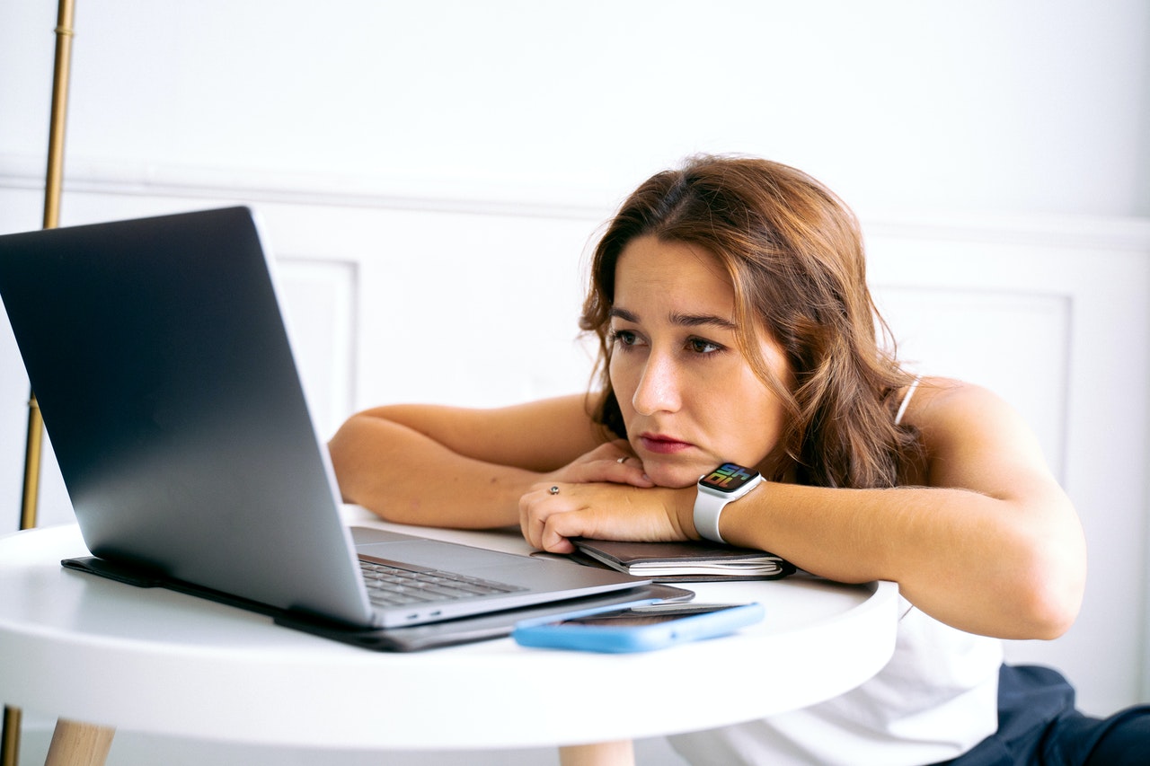 A woman looking sadly at a computer.